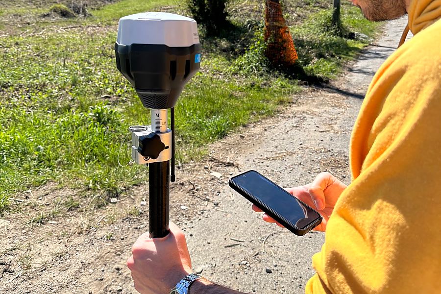 Ricevitore GPS sulla palina e telefono in mano per il rilievo